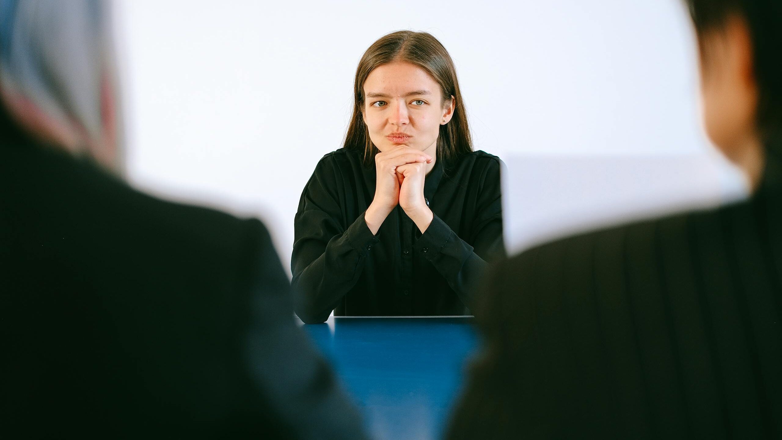 Woman in Black Blazer Sitting Being Interview - Competitive hiring process
