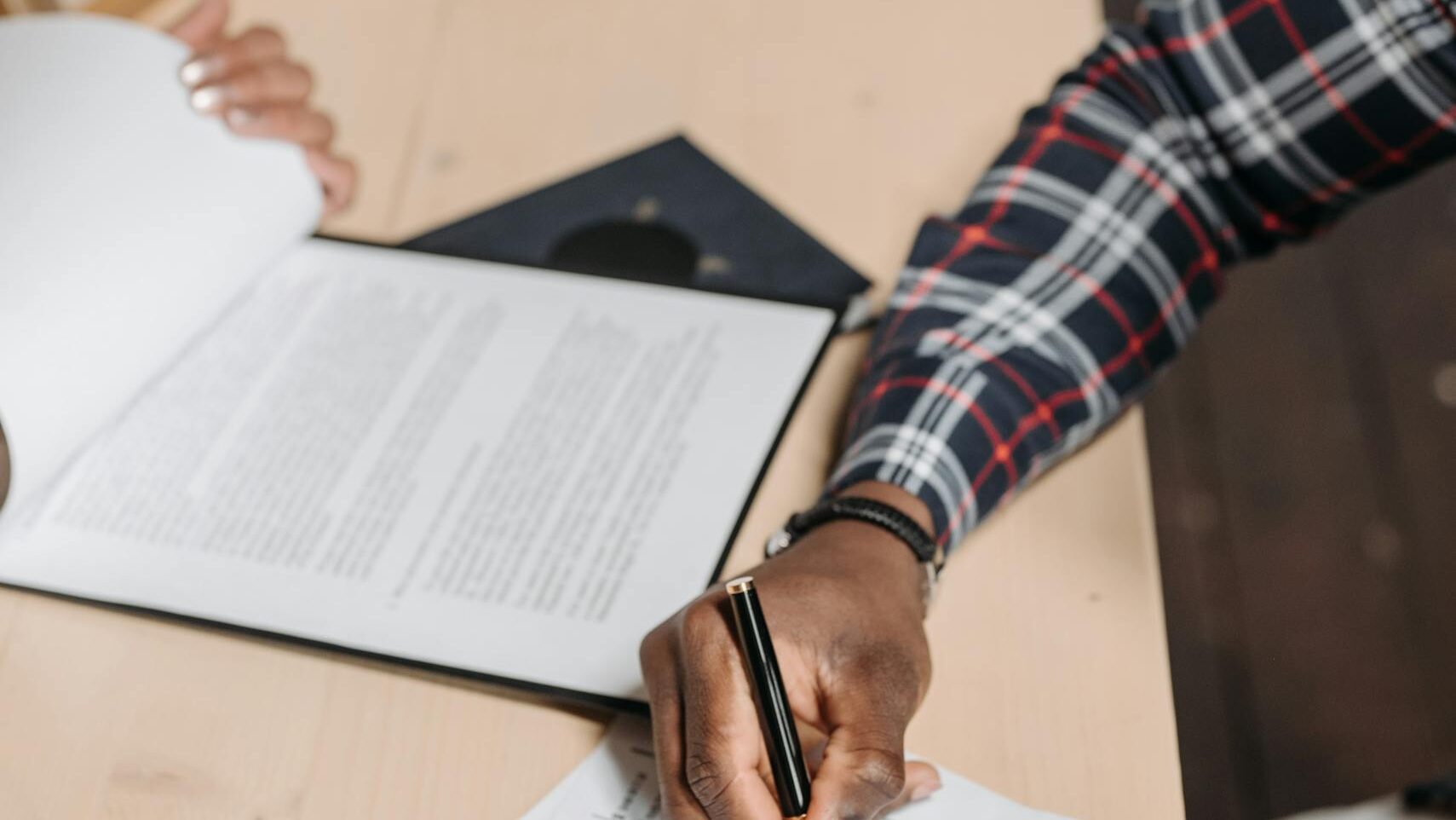 Man Signing Documents on Desk