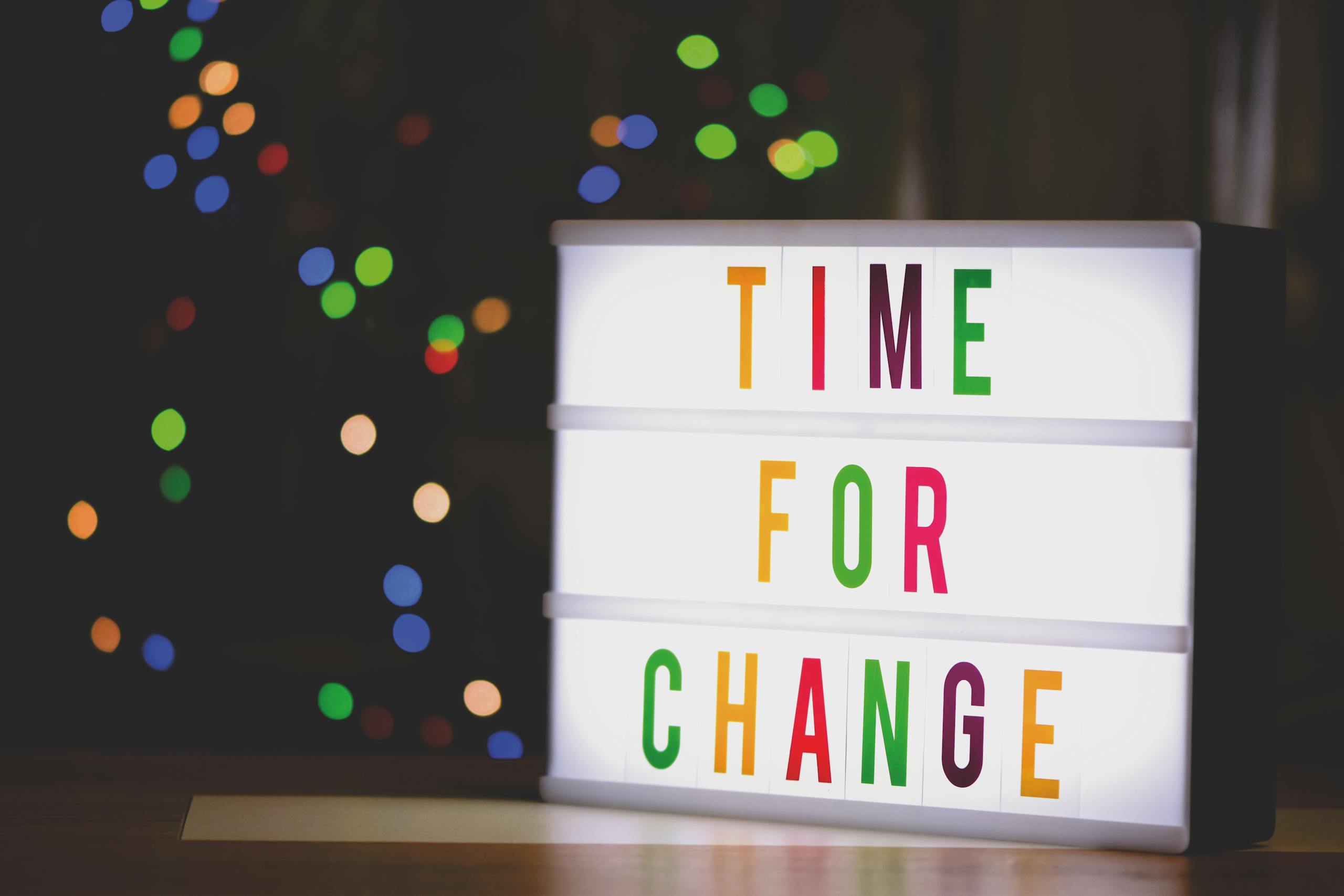 Colorful illuminated sign displaying the motivational message 'Time for Change'.